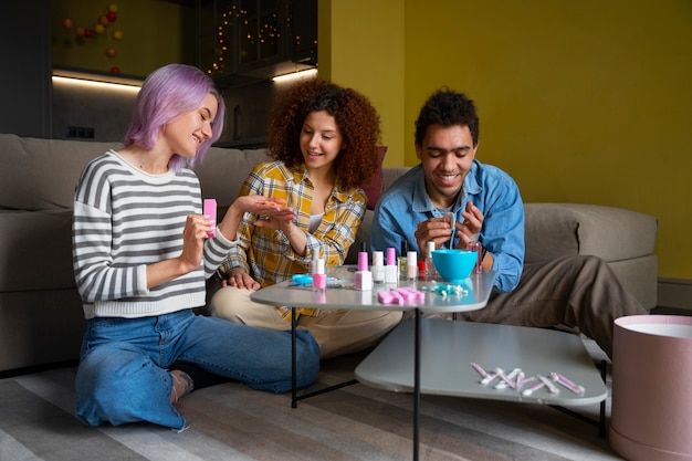 Amigos masculinos y femeninos haciéndose la manicura juntos