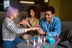 Foto gratuita amigos masculinos y femeninos haciéndose la manicura juntos