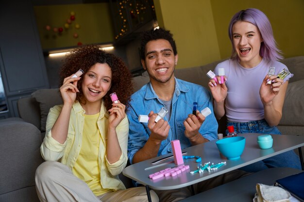 Amigos masculinos y femeninos haciéndose la manicura juntos