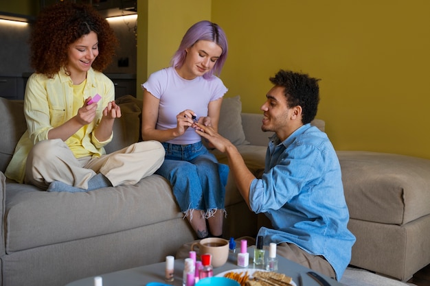 Foto gratuita amigos masculinos y femeninos haciéndose la manicura juntos