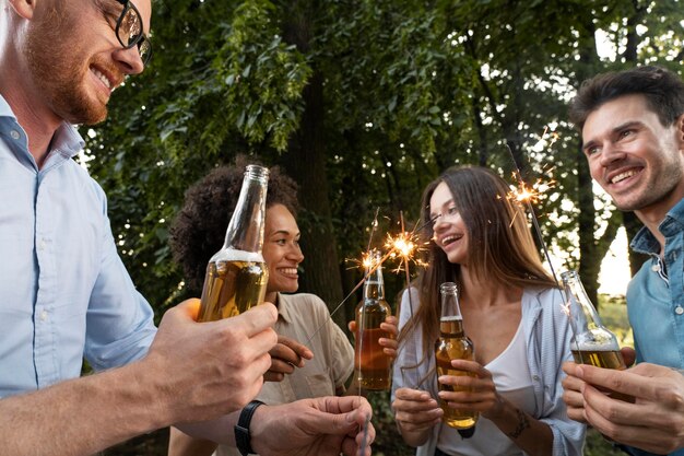 Amigos masculinos y femeninos pasar tiempo juntos al aire libre y tomar cerveza