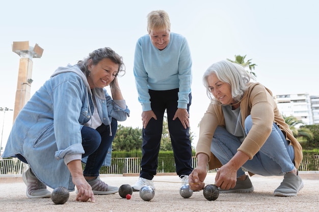 Foto gratuita amigos mayores jugando petanca