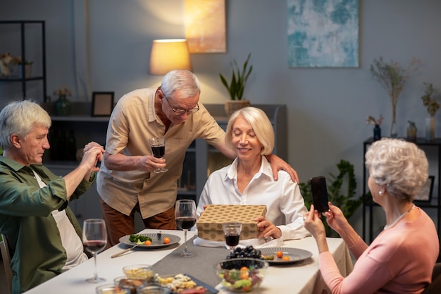 Amigos mayores que tienen una fiesta por la noche