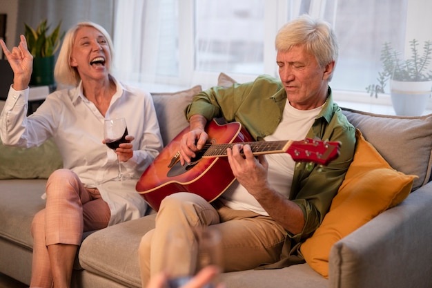 Amigos mayores que tienen una fiesta por la noche