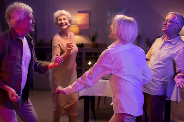 Amigos mayores que tienen una fiesta por la noche