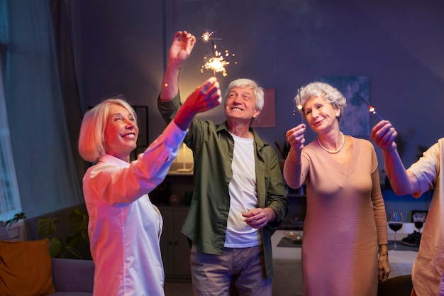 Amigos mayores que tienen una fiesta por la noche