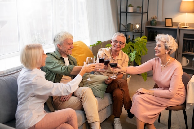 Amigos mayores que tienen una fiesta por la noche