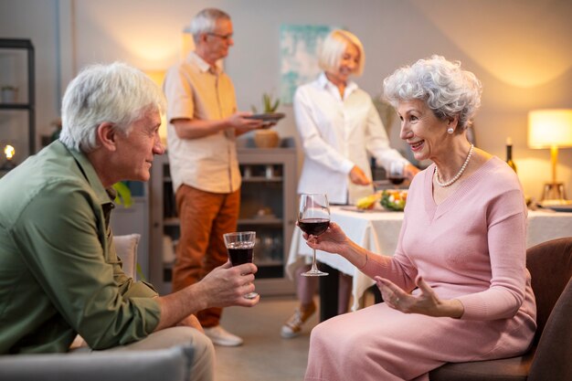 Amigos mayores que tienen una fiesta por la noche