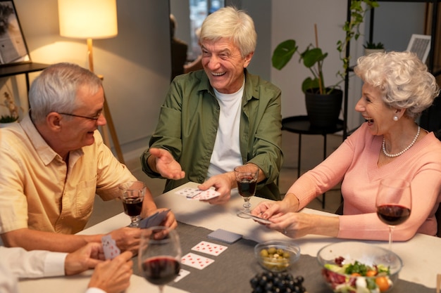 Amigos mayores que tienen una fiesta por la noche