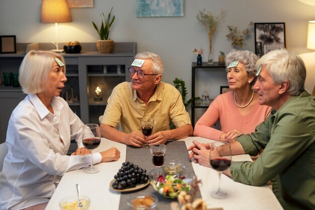 Amigos mayores que tienen una fiesta por la noche