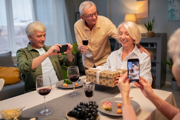 Amigos mayores que tienen una fiesta por la noche