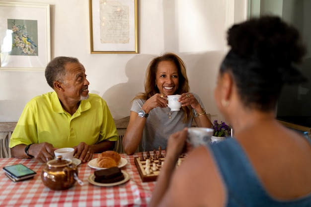 Foto gratuita amigos mayores sonrientes con tazas de té tiro medio