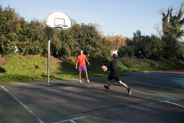 Amigos de mediana edad divirtiéndose juntos jugando baloncesto