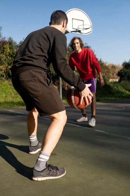 Amigos de mediana edad divirtiéndose juntos jugando baloncesto