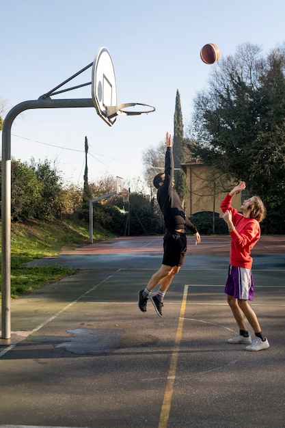 Amigos de mediana edad divirtiéndose juntos jugando baloncesto