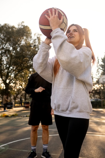 Amigos de mediana edad divirtiéndose juntos jugando baloncesto