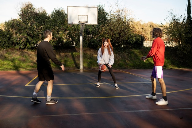 Amigos de mediana edad divirtiéndose juntos jugando baloncesto