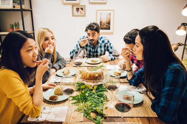 Foto gratuita amigos en mesa comiendo tarta