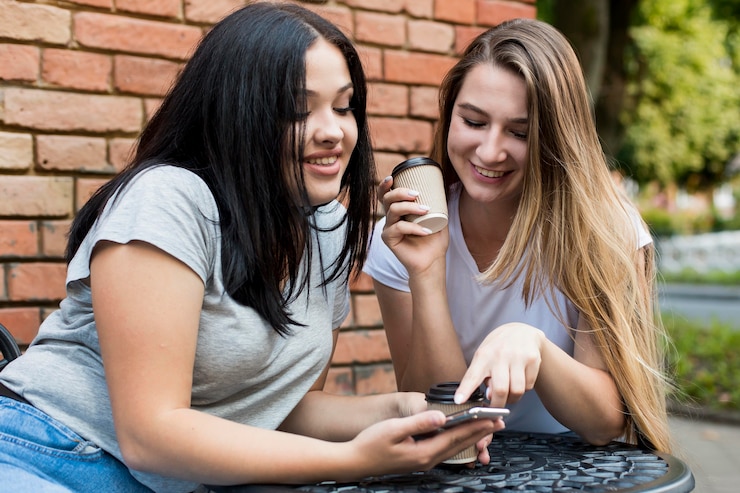 Foto gratuito amigos mirando algo divertido en un teléfono inteligente.
