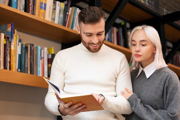 Amigos mirando un libro en una biblioteca