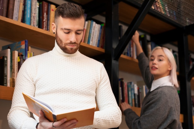 Amigos mirando un libro en una biblioteca