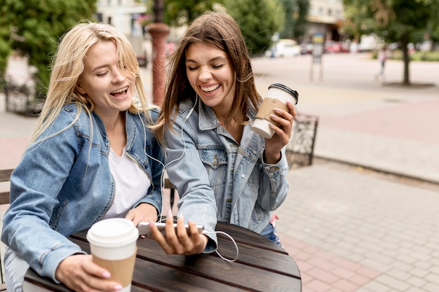 Amigos mirando un teléfono afuera