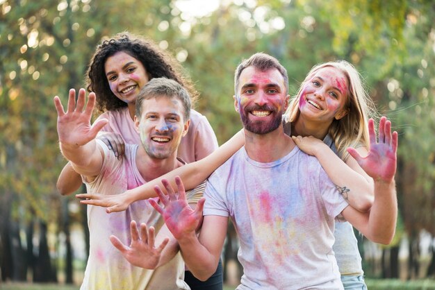 Amigos mostrando sus palmas de colores en holi