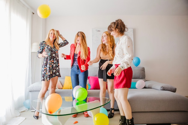 Amigos de las mujeres festivas con globos