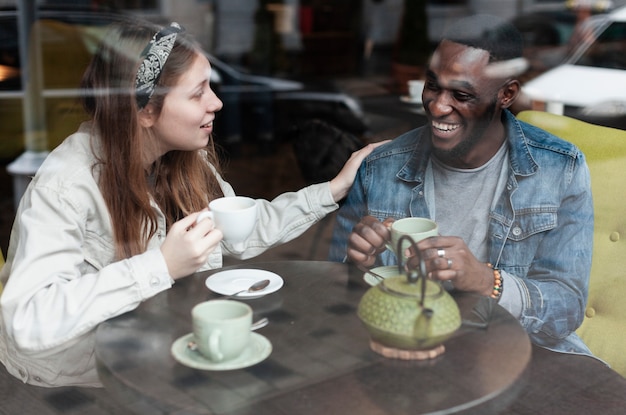 Amigos multiculturales riéndose juntos en el interior