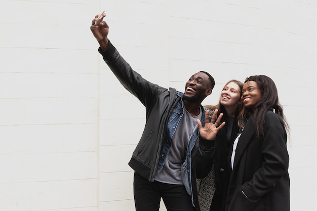 Amigos multiculturales tomando espacio de copia selfie