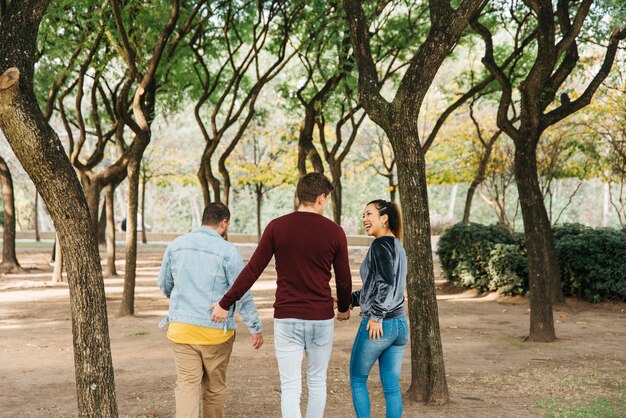 Amigos multiétnicos riendo y caminando en el parque