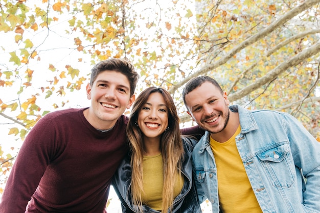 Amigos multiétnicos sonriendo y abrazándose