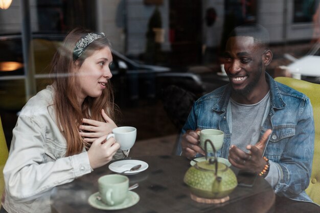 Amigos multirraciales hablando en interiores