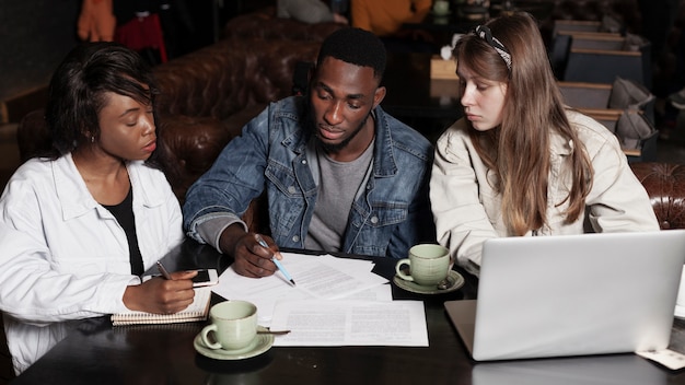 Amigos multirraciales que trabajan en interiores