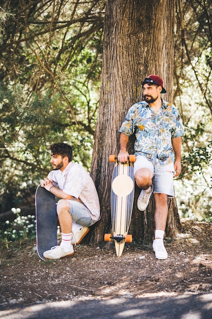 Amigos con patinetas en bosque