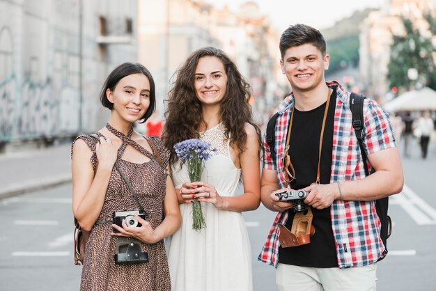 Amigos de pie en la calle con cámaras