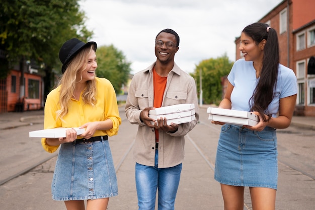 Amigos con pizza al aire libre vista frontal