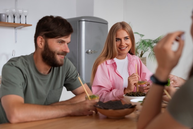 Foto gratuita amigos de plano medio comiendo bocadillos de algas