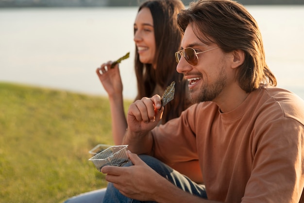 Amigos de plano medio comiendo bocadillos de algas