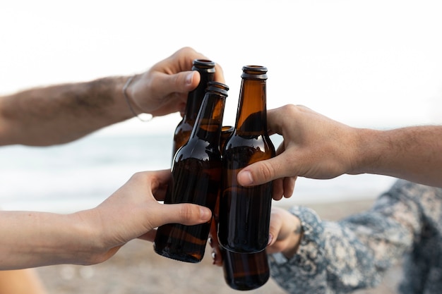 Amigos en la playa con botellas de cerveza