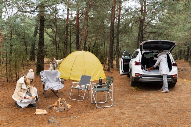 Amigos preparándose para acampar mientras viajan