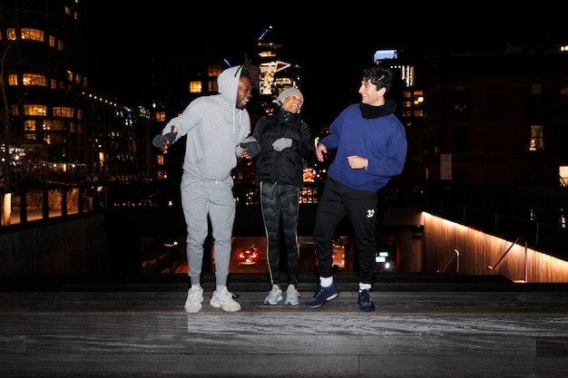 Amigos preparándose para salir a correr por la noche en la ciudad