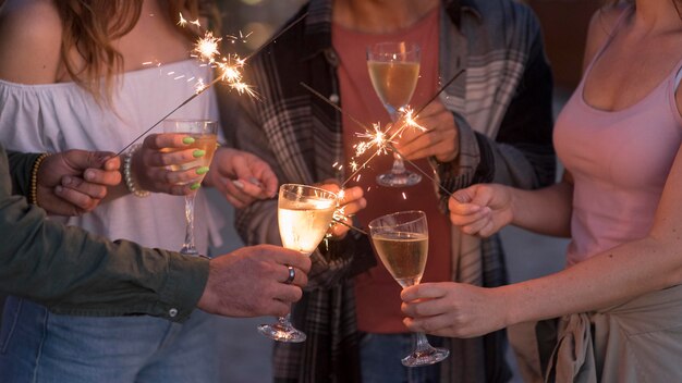 Amigos de primer plano de fiesta con fuegos artificiales