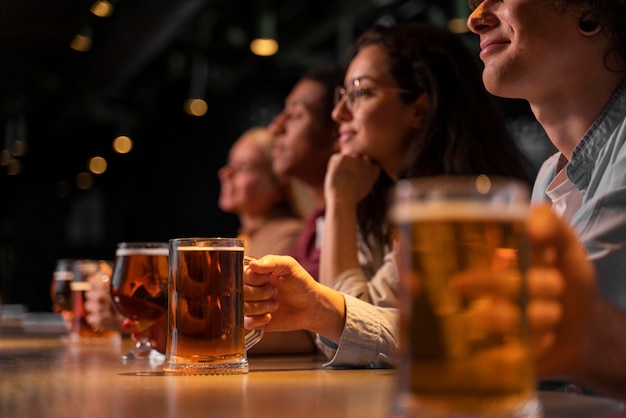 Amigos de primer plano sosteniendo jarras de cerveza