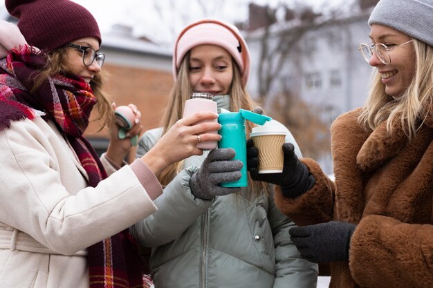 Amigos de primer plano sosteniendo tazas de café