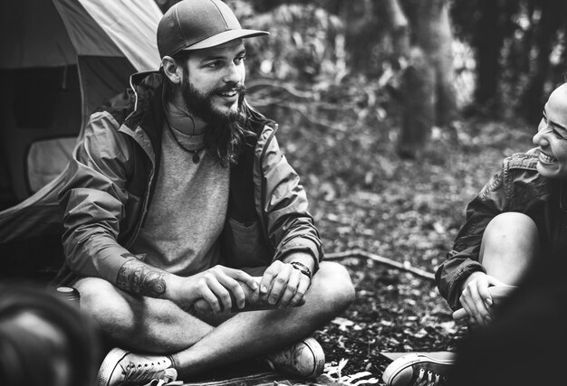 Amigos que acampan en el bosque juntos