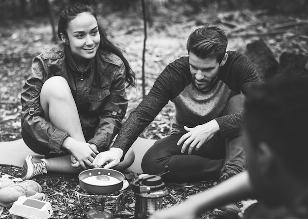 Amigos que acampan en el bosque juntos