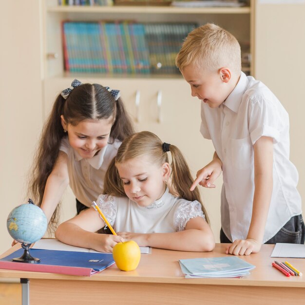 Amigos que ayudan a la niña a realizar ejercicio