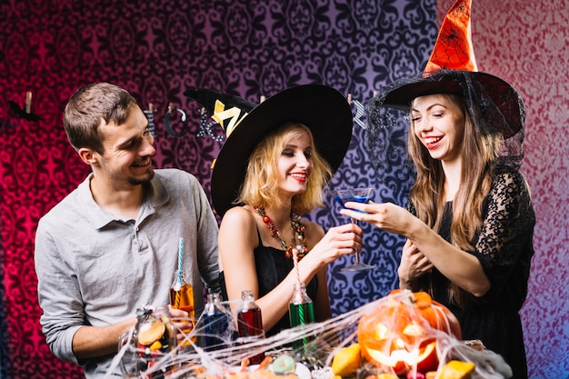 Amigos que beben en la fiesta de Halloween