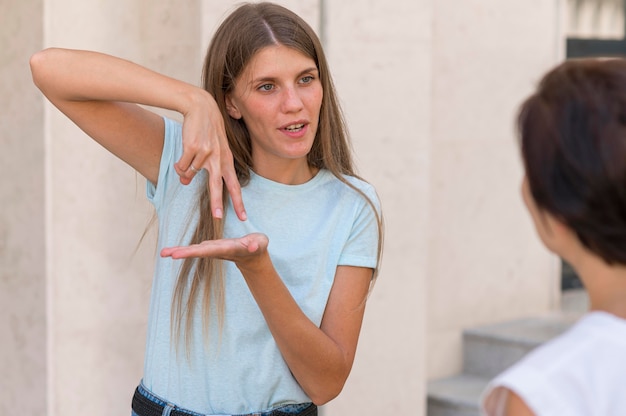 Foto gratuita amigos que se comunican entre sí mediante el lenguaje de señas.
